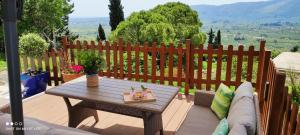 a patio with a wooden fence and a table at Villa Pigi in Meson Yerakarion