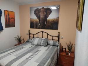Un dormitorio con una cama con una foto de un elefante en EL PINAR DE BARDENA, en Carcastillo