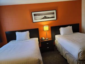 a hotel room with two beds and two lamps at Roadking Inns Motel in Calgary