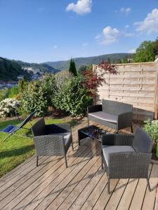 un patio avec des chaises et une table sur une terrasse dans l'établissement Ferienwohnung Am Wald, à Bad Herrenalb