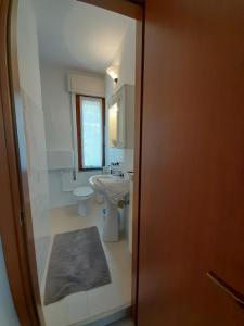 La salle de bains est pourvue d'un lavabo blanc et de toilettes. dans l'établissement Casa Giulia sul Garda, à Tignale