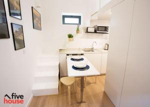 a white kitchen with a sink and a table at FIVE HOUSE 20 in Porto