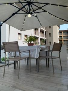 een tafel en stoelen onder een parasol op een patio bij Casa Miki in Sarnico