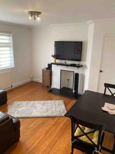 a living room with a black table and a tv at One bed cozy flat in Dartford