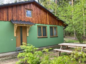 a green cabin with a picnic table in front of it at Chaty Dvořiště in Lomnice nad Lužnicí