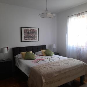 a bedroom with a bed with green pillows and a window at House Dina in Pula