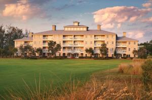 a large building on a golf course with a green at Club Wyndham Dye Villas in North Myrtle Beach