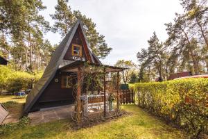 a small black house with a pointed roof at Domek letniskowy Keja in Skorochow +24 photos