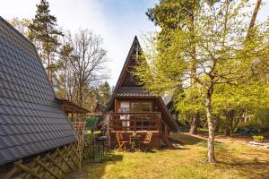 una cabaña en el bosque con mesa y sillas en Domek letniskowy Keja, en Skorochow