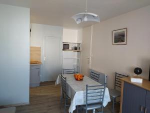 eine Küche und ein Esszimmer mit einem Tisch und Stühlen in der Unterkunft Appartement restauré à 50 m de la plage in Saint-Hilaire-de-Riez