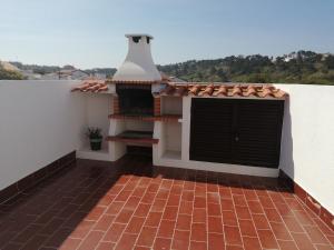 a balcony with a tile floor and a building at Casa do Mar in Foz do Arelho