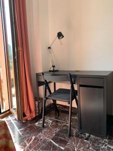 escritorio con lámpara y silla junto a una ventana en B&B GENOVA COUNTRY, en Fegino