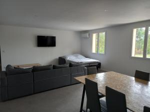 een woonkamer met een bank, een tafel en een bed bij Gîte du centre equestre du val d'or in Fontaine-sur-Ay