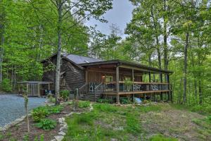 eine Blockhütte im Wald mit einer Veranda in der Unterkunft Hendersonville Cabin with Deck and Mountain Views in Hendersonville