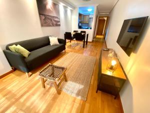 uma sala de estar com um sofá preto e uma mesa em Apartamento Arrecife em Arrecife