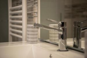 un lavandino con rubinetto e specchio di Aris Appartamento Torino a Torino