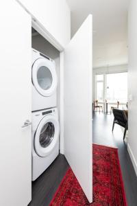 a laundry room with a washer and dryer and a red rug at Flexhome Skywalk to Fiserv 1BR Apt U5 - READ INFO in Milwaukee