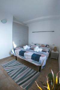 una camera con 2 letti e un tappeto di West Sardinia Apartments a Càbras
