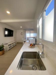 a kitchen with a sink and a large window at Precioso ático con vistas al mar Parking gratuito in Corralejo