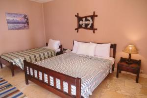 a bedroom with two beds and a table with a lamp at Sayadeen Village - Red Sea Riviera in Nuweiba