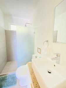 een badkamer met een wastafel, een toilet en een douche bij Altamar in Santa Teresa Beach