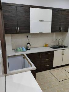 a kitchen with brown cabinets and a white counter top at T House Nearby Kuantan East Coast Shopping Mall in Kuantan