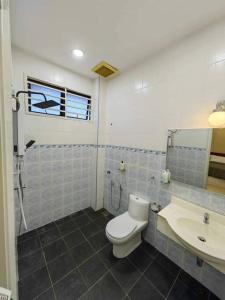 y baño con aseo y lavamanos. en T House Nearby Kuantan East Coast Shopping Mall, en Kuantan