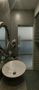 La salle de bains est pourvue d'un lavabo blanc et d'un miroir. dans l'établissement Calma Suite (Cielo suites), à Kavala