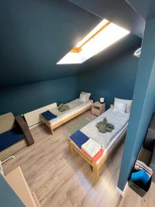 dwa łóżka w pokoju z niebieskimi ścianami i drewnianą podłogą w obiekcie Przy starówce w Kołobrzegu