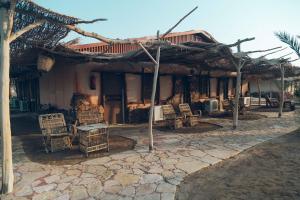 a house with chairs and a building with a roof at Sayadeen Village - Red Sea Riviera in Nuweiba