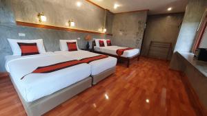 a hotel room with two beds and a table at Safina Pool Villa Koh Lanta in Ko Lanta