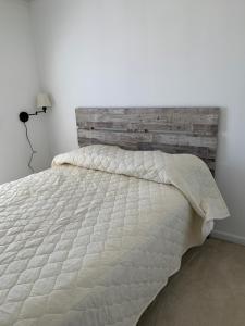 a bedroom with a white bed with a wooden headboard at 37100 turnstone circle in Rehoboth Beach