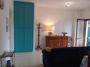 uma sala de estar com um sofá e uma porta verde em Struttura con accesso diretto in spiaggia em San Felice Circeo