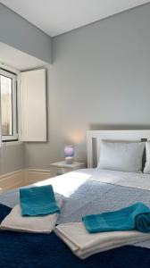 una camera da letto con un letto grande con due asciugamani sopra di São Bartolomeu Apartment 1 a Coimbra