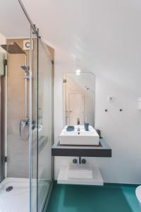 een badkamer met een wastafel en een glazen douche bij BeSmart Residence in Aveiro