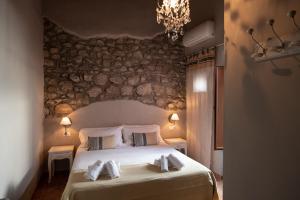 Schlafzimmer mit einem Bett mit weißer Bettwäsche und Kissen in der Unterkunft Hotel Borgo Vistalago in Trevignano Romano