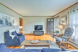 uma sala de estar com mobiliário azul e uma televisão em Tasteful Country Home on 5 Acres about 3 Mi to Lake! 