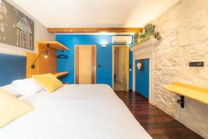 1 dormitorio con 1 cama blanca y paredes azules en Domus Maritima en Trogir