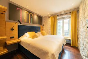 a bedroom with a large bed with yellow pillows at Domus Maritima in Trogir