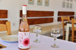 una bottiglia di vino seduta su un tavolo con due bicchieri di Rooms Kochilas Elafonisi a Elafonisi