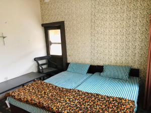Un dormitorio con una cama con una manta. en Al-Noor Cottage en Rawalpindi