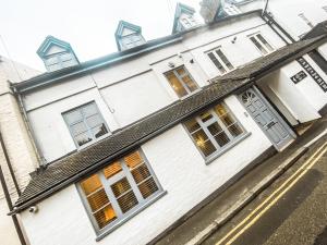 ein weißes Haus mit schwarzem Dach in der Unterkunft The Bridge at Riverside Suites in Bridgnorth