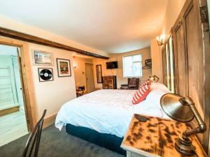 a bedroom with a bed and a desk with a lamp at The Bridge at Riverside Suites in Bridgnorth