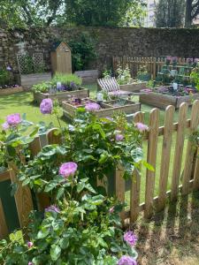 une clôture en bois dans un jardin avec des roses roses roses dans l'établissement Le Celadon, à Montaigu-Vendée