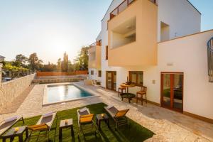 a villa with a swimming pool and a patio at Vila Rušinac - private heated pool in Kaštela