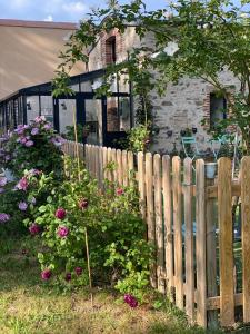 une clôture en bois devant une maison fleurie dans l'établissement Le Celadon, à Montaigu-Vendée