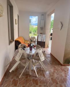 a dining room with a table and four chairs at Casa vacanza Giovannella in Custonaci
