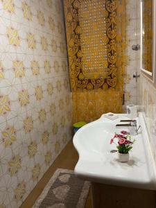 a bathroom with a white sink with flowers on it at Casa vacanza Giovannella in Custonaci