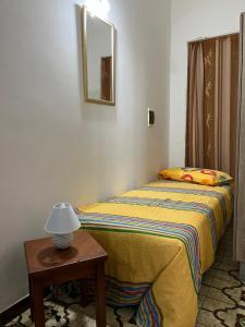 a bedroom with a bed and a table with a lamp at Casa vacanza Giovannella in Custonaci