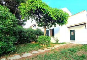 a white house with a tree in the yard at Sa Mar in Cala'n Bosch